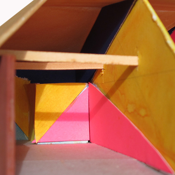 study model of forced perspective paint design, triangulating walls in bright yellow, navy, pinkish-red and bright green, in kids STEM after-school studio, Iridescent, LA