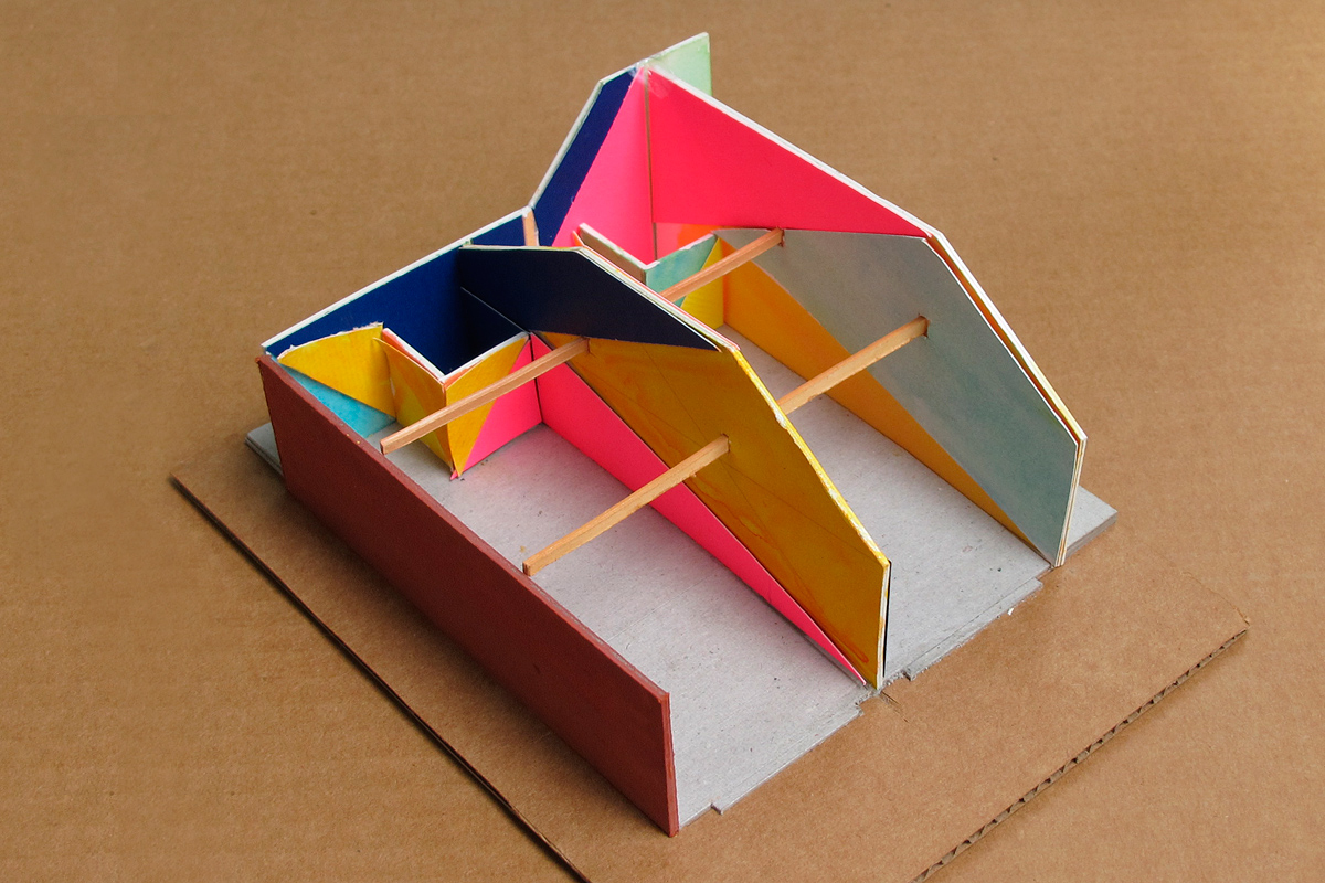 study model of forced perspective paint design, triangulating walls in bright yellow, navy, pinkish-red and bright green, in kids STEM after-school studio, Iridescent, LA